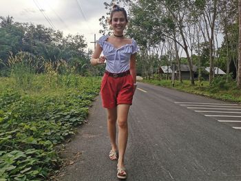 Full length portrait of woman walking on road