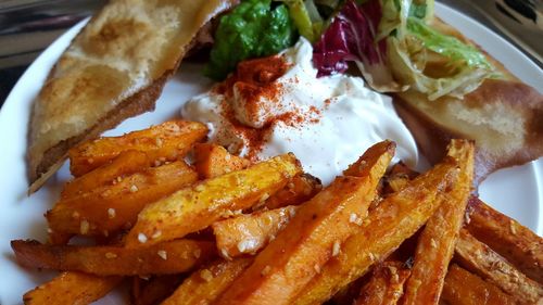 Close-up of french fries with yogurt served in plate