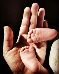 Close-up of human hand against black background