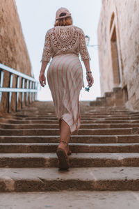 Rear view of woman walking on staircase