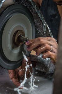 Cropped image of craftsperson polishing gemstone