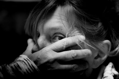 Cropped hand covering woman mouth in darkroom