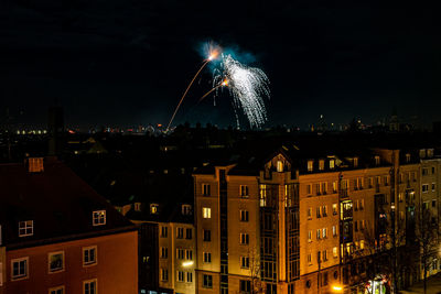 Firework display over illuminated buildings in city at night