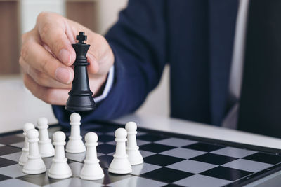 Midsection of businessman playing chess