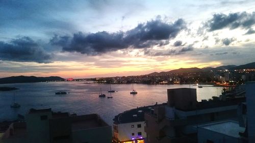 Boats in river with city in background