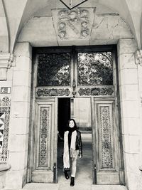 Full length rear view of woman standing at entrance of building