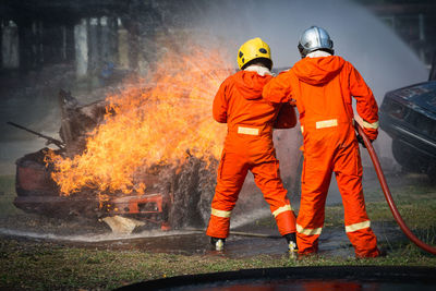 Rear view of firefighters extinguishing fire