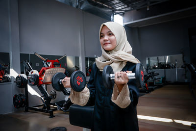 Portrait of young woman exercising in gym