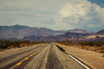 Road amidst snowcapped mountains against sky