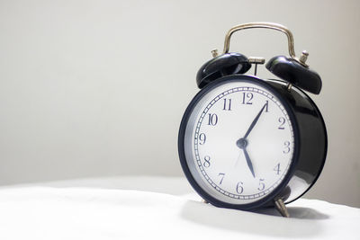 Close-up of clock on table against wall