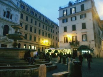 Illuminated street amidst buildings in city at night