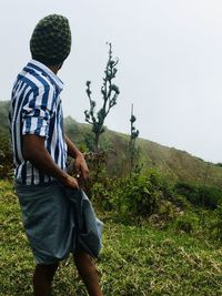 Side view of man on field against sky