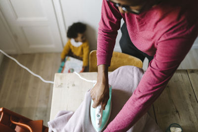 Father ironing clothes at home