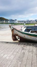 View of boat on footpath against cloudy sky