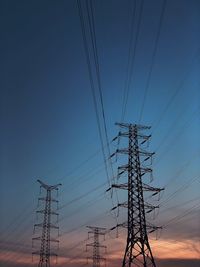 Low angle view of electricity pylon against clear sky