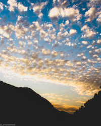 Low angle view of silhouette mountains against sky at sunset