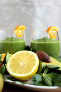 Close-up of lime by fresh green smoothies served on table