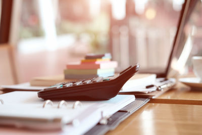 Close-up of calculator on diary at desk in office