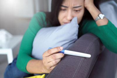 Midsection of woman sitting at home