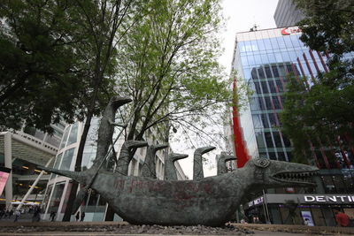 Low angle view of trees and buildings against sky