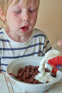 Close-up of cute boy eating food at home