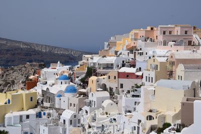 Buildings in city against clear blue sky