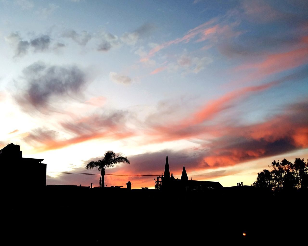 LOW ANGLE VIEW OF SILHOUETTE BUILDINGS AGAINST ORANGE SKY