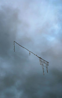 Low angle view of silhouette barbed wire against sky