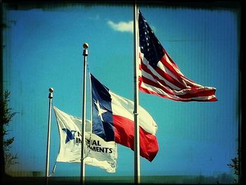 Low angle view of american flag against blue sky