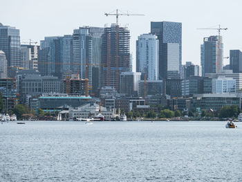 Modern buildings by sea against sky in city