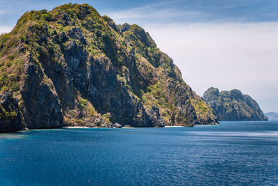 Scenic view of mountains in sea against sky