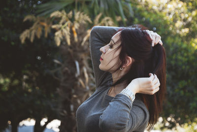 Woman with hand in hair standing outdoors