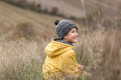 Side view of man wearing hat standing on field