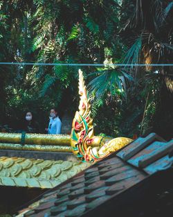 Statue of angel against trees and plants