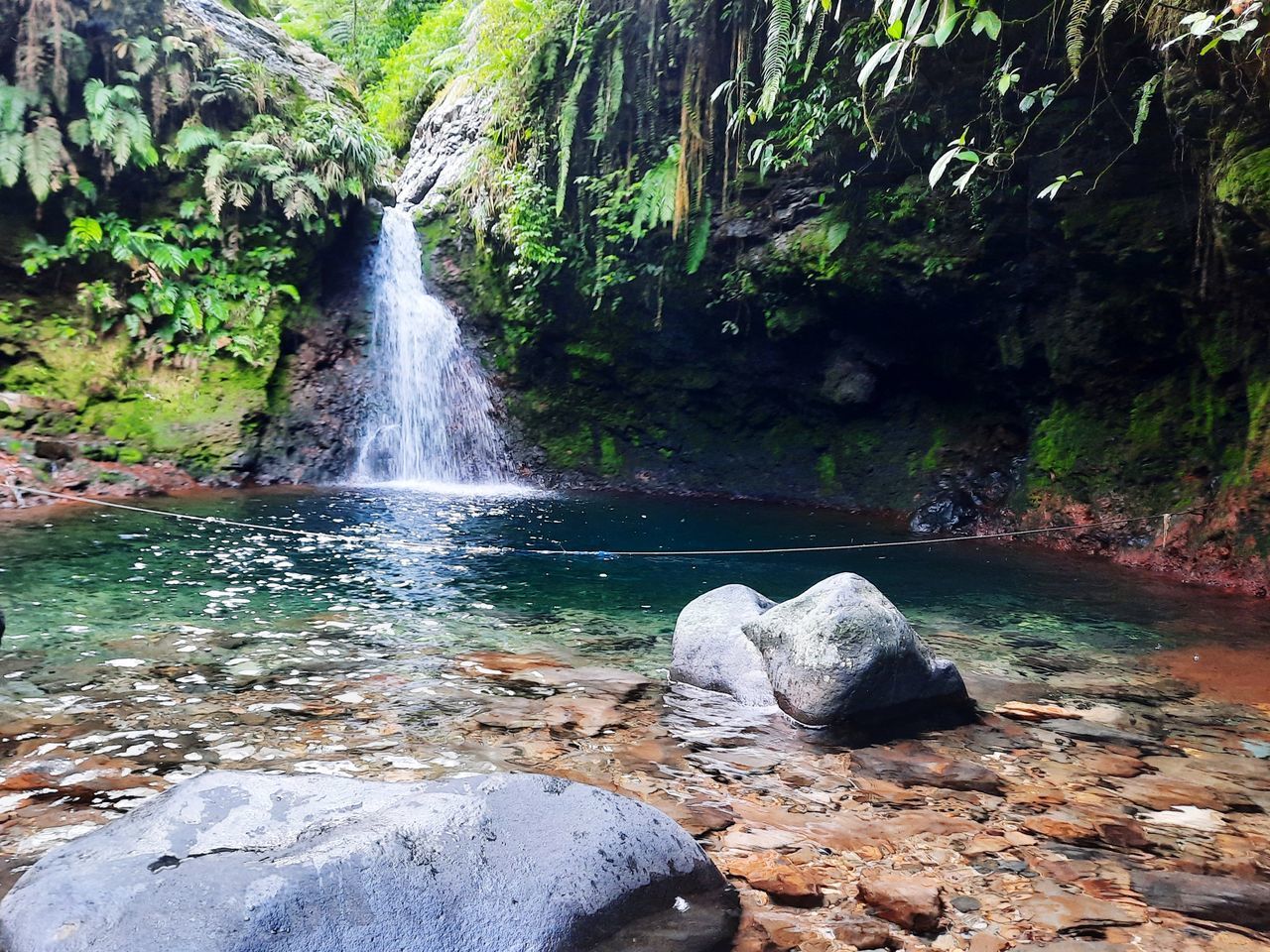 SCENIC VIEW OF WATERFALL AGAINST ROCKS