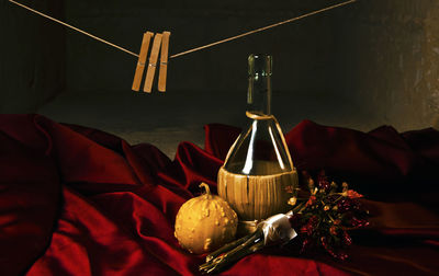 Close-up of pumpkin with container and bouquet on table