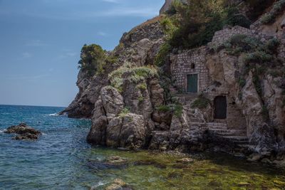 Rock formations by sea against sky