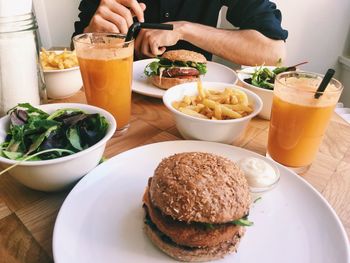 Midsection of man having food and drink at home