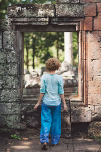 Rear view of woman standing against building