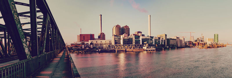 River by industrial district against sky