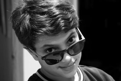 Close-up portrait of boy wearing sunglasses at home