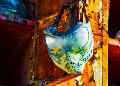 Close-up of rusty metal hanging on wood