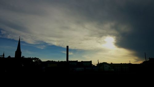 Buildings against cloudy sky at sunset