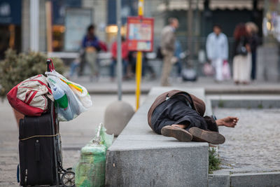 People on sidewalk by street in city