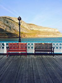 View of deck chairs in water