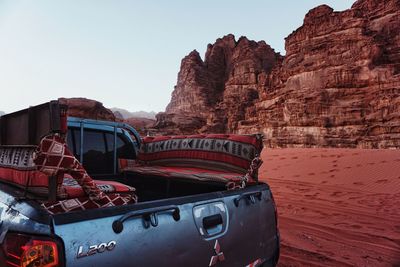 View of abandoned car on mountain against clear sky