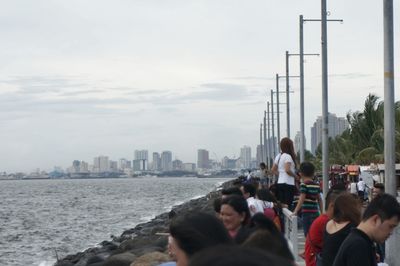 Man standing on promenade by sea