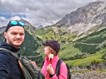 Portrait of man with woman in mountains against sky