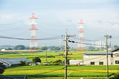 Electricity pylon on field against sky