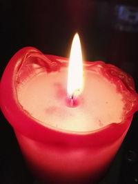 Close-up of lit candle in dark room